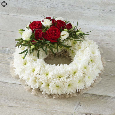 Traditional Wreath - A traditional wreath of white chrysanthemums contrasted with a cluster of pretty roses, lisianthus and delicate foliage.

The image shows Large Size

Please note: for seasonal and other supply reasons, we may occasionally substitute some of the blooms shown in the image. We will always try to be true to the bouquet's colour coordination, style, and shape and guarantee to give you the full value paid. If you have any queries, please email or call us and we would be delighted to confirm availability and explain alternatives. See the 'Contact Us' section.