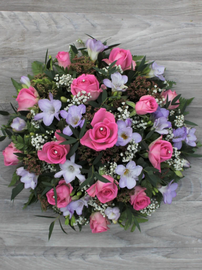 Classic Posy Lilac & Pink - A pretty pink and purple posy pad featuring pink Roses and freesia, presented in a posy design by Go Dutch Flowers.

Please Note: The image relates to the standard variant.