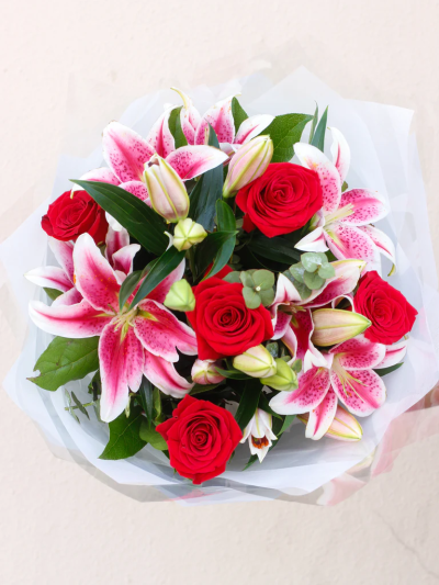 Red Rose and Lily Hand-tied - This showcase bouquet is a stunning display of the most popular flower varieties: classic roses and exotic Oriental lilies. The pink petals of these luxurious lilies with their dark centres blend beautifully with the rich red roses. This hand-tied is certainly designed to impress.

Featuring pink Oriental lilies and large-headed red roses, eucalyptus and salal leaves hand-tied and presented in our gift packaging.

The image shows Large Size

Please note: for seasonal and other supply reasons, we may occasionally substitute some of the blooms shown in the image. We will always try to be true to the bouquet's colour coordination, style, and shape and guarantee to give you the full value paid. If you have any queries, please email or call us and we would be delighted to confirm availability and explain alternatives. See the 'Contact Us' section.